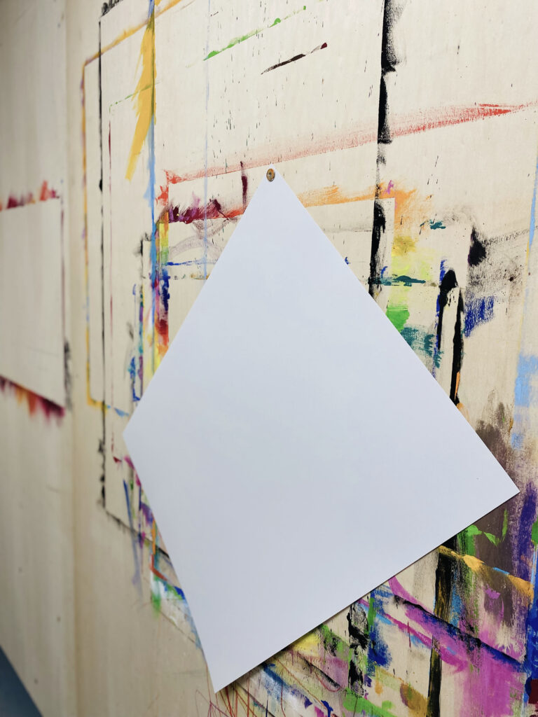 Ein Blatt Papier hängt an der Wand und wartet darauf, dass du deine Malspuren hinterlässt